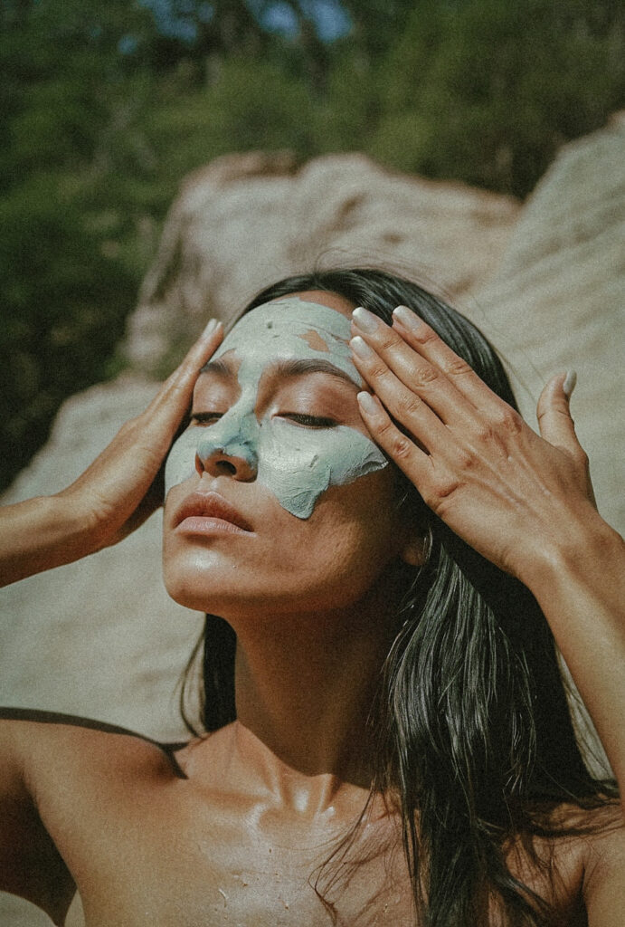 woman spreading green face cream on